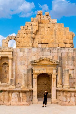 Jerash, Ürdün - 7 Kasım 2022: Antik Gerasa arkeoloji sahasındaki Roma amfitiyatrosunda mutlu kadın