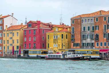 Venedik, İtalya - 1 Ekim 2024: Su taksisi veya otobüs, vaporetto ve arka planda güzel Venedik evleri.