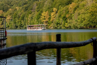 Plitvice Lakes, Hırvatistan - 22 Eylül 2024: Gezi teknesi üzerindeki turistler, Plitvice Gölleri Ulusal Parkı 'nın sonbahar manzarası