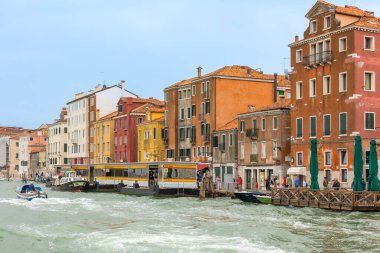 Venedik, İtalya - 1 Ekim 2024: Su taksisi veya otobüs, vaporetto ve arka planda güzel Venedik evleri.