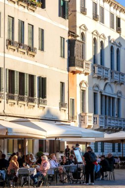 Venedik, İtalya - 30 Eylül 2024: İnsanlar küçük bir kafenin terasında oturuyorlar