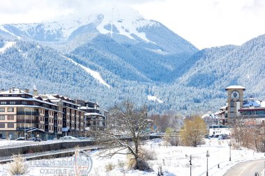 Bansko, Bulgaristan - 7 Nisan 2025: Glazne nehri, Bulgar kenti, otel evleri ve kar Pireni dağlarının zirveleri