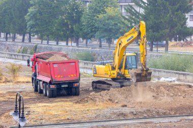 Bansko, Bulgaristan - 25 Eylül 2025: Sanayi kazıcısı bir çöp kamyonuna toprak yüklüyor