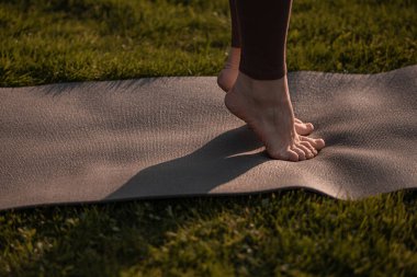 Yazın ya da sonbahar parkında yoga minderli yoga kızı.