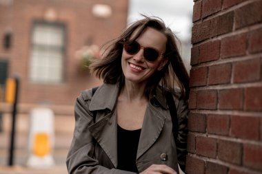 Kadınlar sonbahar tatillerinde bej yağmurluk giyerek harika bir atmosferden hoşlanırlar.