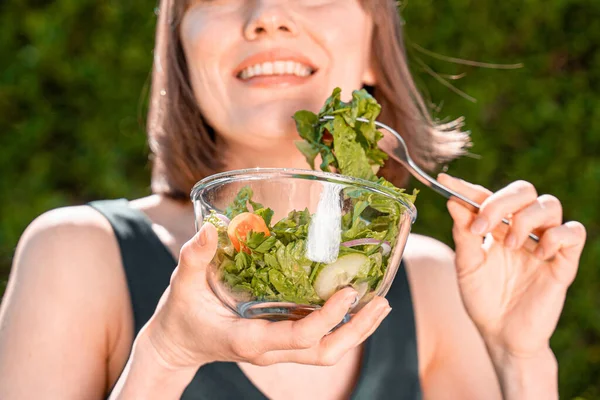 Mulher Bonita Comendo Salada Sobre Fundo Natural Verde — Fotografia de Stock