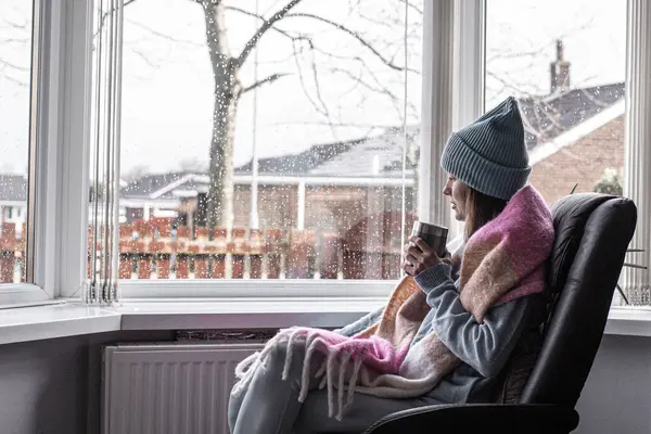 Üzgün Kadın Sıcak Çay Içiyor Pencerenin Yanında Oturuyor — Stok fotoğraf