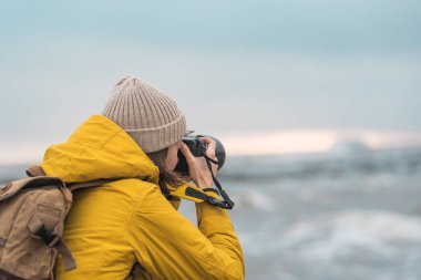 Turist fotoğrafçısı, Kuzey Denizi 'nin arka planında fotoğraf çekiyor.
