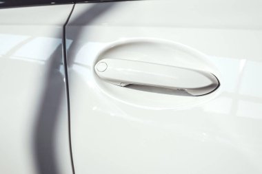 Beyaz bir arabaya yaklaş, detay ver, sapına odaklan.