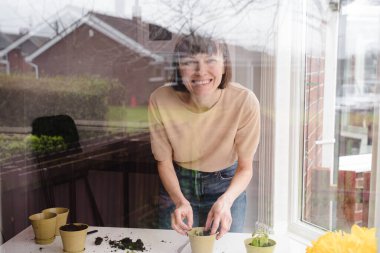 Hevesli kadın bahçıvan dükkanında filizleniyor. Küçük bir girişimci.