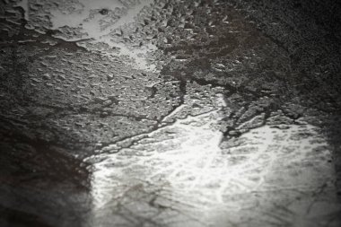 Islak doku arka planı. Metal bir yüzeye saçılmış makro su damlaları, doğa veya soyut temalar için desenli ve taze bir arkaplan oluşturur. Dramatik ve kontrast görünüm, karamsar ışıklandırma, minimalizm