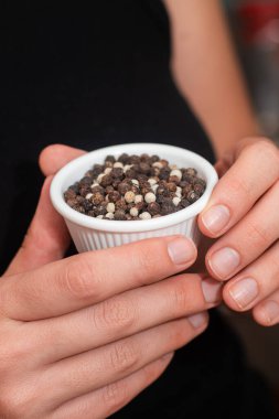 Bowl of Whole Peppercorns in a Female Hands. Gently holding a ramekin filled with assorted whole peppercorns clipart