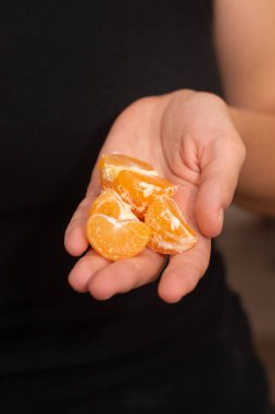 Peeling a Fresh Orange Mandarin. Female Hands skillfully peeling a juicy ripe mandarin clipart