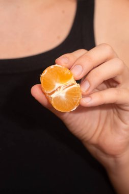 Peeling a Fresh Orange Mandarin. Female Hands skillfully peeling a juicy ripe mandarin clipart