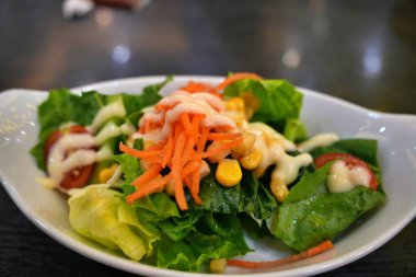 Taze domates, salatalık, soğan, ıspanak, marul ve susamlı sağlıklı sebze salatası. Diyet menüsü.