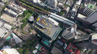 Çalışanlar cam zemini temizler ve ziyaretçiler için izleme alanını hazırlarlar. Bangkok şehir merkezinin havadan görüntüsü. Gökyüzü düzenleyicisi Kral Power MahaNakhon ve gözlem platformundaki insanlar üzerinde uçuyor..