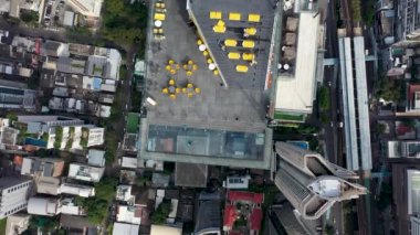 Çalışanlar cam zemini temizler ve ziyaretçiler için izleme alanını hazırlarlar. Bangkok şehir merkezinin havadan görüntüsü. Bangkok 'un en yüksek gökyüzü düzenleyicisi ve gözlem platformundaki insanlar üzerinde uçuyor..