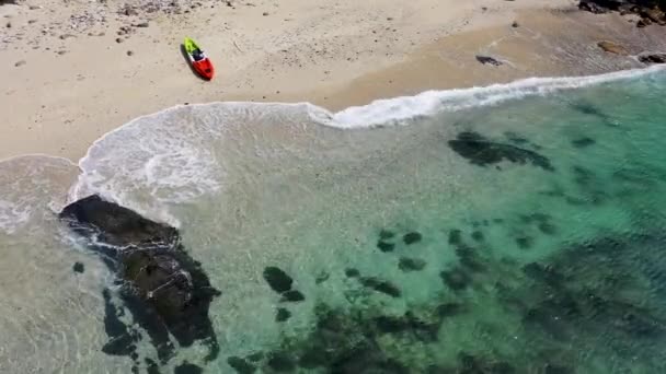 白色沙滩上停放一艘皮划艇的水晶般清澈海滩的海景 — 图库视频影像