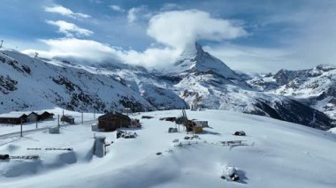 Güneşli bir kış gününde Zermatt 'ta Matterhorn Dağı' nın doruk noktası olan zirve istasyonuna doğru koşan Gornergrat Bahn Demiryolu. İsviçre Alpleri, İsviçre seyahati. 4K Statik Çekim.