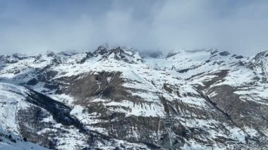 Kışın Furi 'den Riffelberg' e kadar İsviçre 'de kablolu bir araba. Arka planda dağ sırtı.