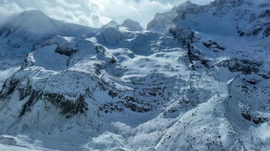 İsviçre 'nin karanlık engebeli dağının yamacında karla kaplı buzullar..