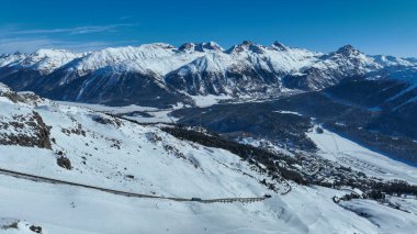 Kış mevsiminde Corviglia 'dan Sankt Moritz manzarası. Güneşli bir kış günü Alpler 'de, Sankt Moritz ve Silvaplana köyünün yakınlarındaki karlı dağlar..
