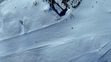 Kayakçılar yokuş aşağı kayıyorlar. Karlı arazide kayakçının hava görüntüsü. Karlı manzaranın yukarıdan aşağı görüntüsü.