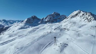 Güneşli bir günde kış yüksek dağı Piz Nair. Engadin kayak merkezi Saint Moritz 'de uzun kayak pistleri, asansörler, kayakçılar, snowboardcular ve karlı dağlar.