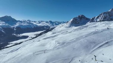 Kışın Piz Nair Dağı 'nın havadan görünüşü. İsviçre 'deki Alplerdeki Engadin kayak merkezinde kayakçılar ve sandalye asansörü. İsviçre 'de St. Moritz yakınlarında İsviçre Alplerinde kayak yamacı.