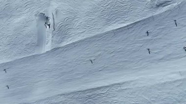 Güneşli bir günde kayak yapan insanların hava manzarası. Kış tatili Alp dağlarının tepelerinde kar yamaçlarını kapladı. Kayakçı Winter. Geniş açılı drone görünümü