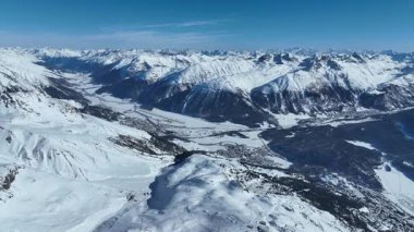 Kayakçılar ve snowboardcular kar yamaçlarında kayak yapıyorlar. Buzlu bir kış gününde Kayakçılar ve Snowboardcularla karlı yamaçlarda uçan insansız hava aracı..