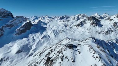İsviçre 'de kış mevsiminde Piz Nair Tepesi' nin havadan görünüşü. Teleferik zirve istasyonuna ulaşıyor. İsviçre 'deki karlı Alpler manzarası.
