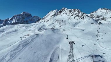 Kışın Piz Nair Dağı 'nın havadan görünüşü. İsviçre 'deki Alplerdeki Engadin kayak merkezinde kayakçılar ve sandalye asansörü. İsviçre 'de St. Moritz yakınlarında İsviçre Alplerinde kayak yamacı.