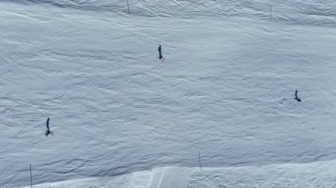 Ingiliz kayak merkezi Saint Moritz 'de beyaz bir dağ yamacında kayak yapan insanlar. Hava manzaralı. Kar, kayakla kaplı yamaçlar açık mavi gökyüzü güneşli bir gün..