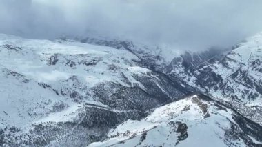 Zermatt Town, Valais, İsviçre. İsviçre Alpleri 'ndeki ikonik güzellikteki bir tatil köyünün yan tarafları. Bulutlu bir kış günü, tipik İsviçre evleri tepelerde, karlı vadide güzel bir nehir ve orman var..