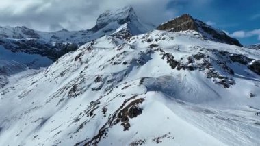 İsviçre Alpleri 'ndeki sisli ve bulutlu bir günde karla kaplı Matterhorn zirvesinin yakın çekim videosu. Doğa, seyahat ve manzara temaları için mükemmel