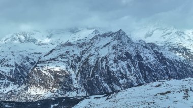 İsviçre, Zermatt 'ta kışın bulutlu gününde karlı dağların havası..