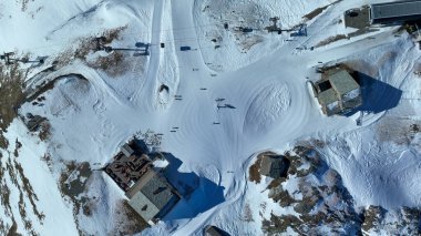 Aşağı manzaralı teleferik istasyonu, restoran ve Schwarzsee 'de kışın piste. Kayakçılarla karlı doğal manzarada hava aracı görüntüsü. Ski areal Zermatt İsviçre 'de.