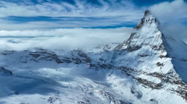 Karla kaplı madde boynuzu dağ zirvesinin manzarası. Güzel kar, gökyüzüne karşı beyaz manzarayı kaplıyor. Kış boyunca Alp bölgesi.