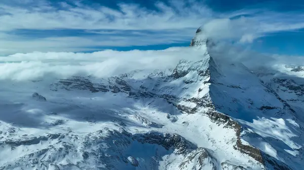 İsviçre Alpleri 'ndeki inanılmaz madde boynuzu ve etrafındaki dağlar fantastik bulut oluşumlarıyla.