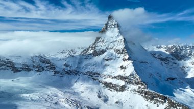 Karla kaplı madde boynuzu dağ zirvesinin manzarası. Güzel kar, gökyüzüne karşı beyaz manzarayı kaplıyor. Kış boyunca Alp bölgesi.