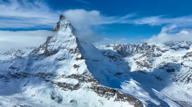 Karla kaplı madde boynuzu dağ zirvesinin manzarası. Güzel kar, gökyüzüne karşı beyaz manzarayı kaplıyor. Kış boyunca Alp bölgesi.