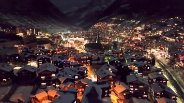Zermatt Vadisi 'nin ünlü kayak merkezi ve İsviçre' nin İsviçre Alplerinde şafak vakti ikonik Matterhorn zirvesinin insansız hava aracı görüntüleri. Kanton Valais 'teki köy ve kilise kışın karla kaplandı..