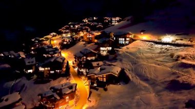 Zermatt 'ta karla kaplı tepelerdeki tipik renkli İsviçre evlerinin gece görüşü. Kış boyunca İsviçre 'nin Zermatt kentindeki Avrupa Alpleri' ndeki Kayak Kasabası 'nın yukarıdan görüntüsü.