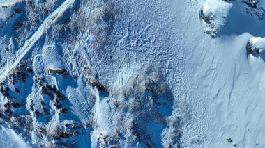 Karlı dağ arazisinin havadan görünüşü ve kışın volkanın etrafındaki aşınma. Doğanın ve manzaranın güzel kuş gözleri. İHA 'nın üst görüntüsü. Toprağın dokusu.