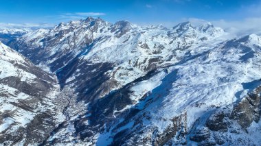 Karlı dağ vadisi ve kasaba. Hava aracı görüntüsü.