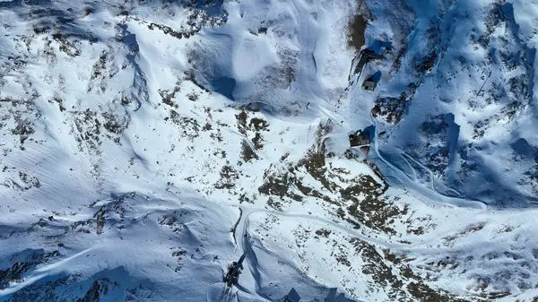 Aşağı manzaralı teleferik istasyonu, restoran ve Schwarzsee 'de kışın piste. Kayakçılarla karlı doğal manzarada hava aracı görüntüsü. Ski areal Zermatt İsviçre 'de.