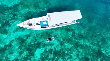 İnsanlar Endonezya 'nın Gili Meno Adası' ndaki ünlü yerin yakınında şnorkelle yüzüyorlar. Hava görüntüsü. Okyanusta sualtı turizmi. Gili Meno Adası, Endonezya. Seyahat resmi.