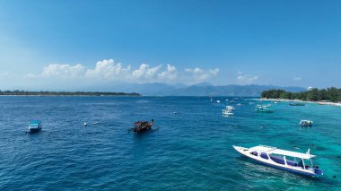 Lombok 'taki Gili Trawangan Adası' nın havadan görünüşü, Gili adalarının demirli küçük tekneleri, turkuaz deniz suları ve turkuaz tekneleri..
