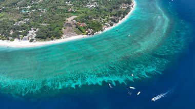 Sığ resifler ve derin mavi sularla çevrili bir mercan adası anteni..